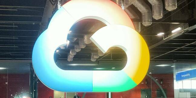 A large, illuminated Google Cloud logo in the shape of a multi-colored cloud, hanging from a ceiling in an indoor space