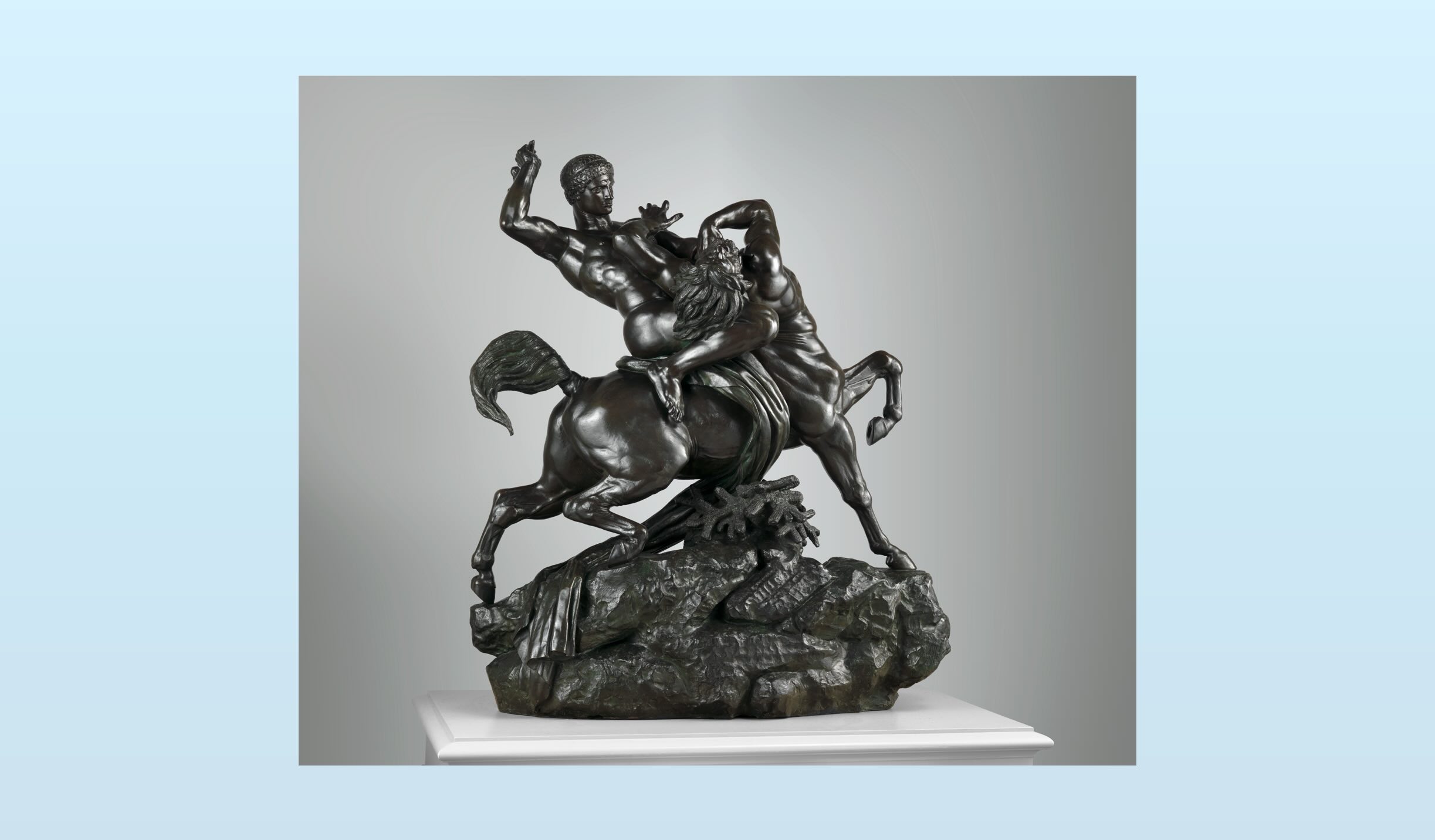 Bronze sculpture of a dynamic battle between two centaurs, one rearing and grappling the other in a dramatic pose atop a rocky base.