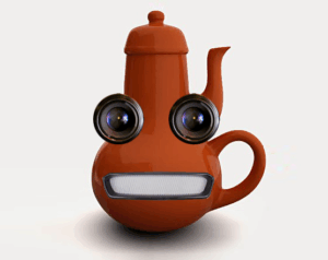A rust-colored teapot where the handle is located directly beneath the spout, making it impossible to pour. It has two lenses for eyes and a metal grille mouth.